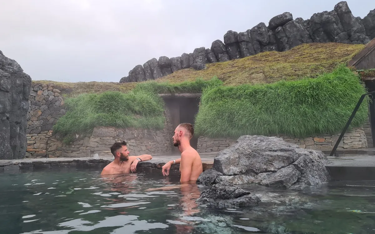A geothermal Lagoon at dusk with the pool edge running out toward open water
