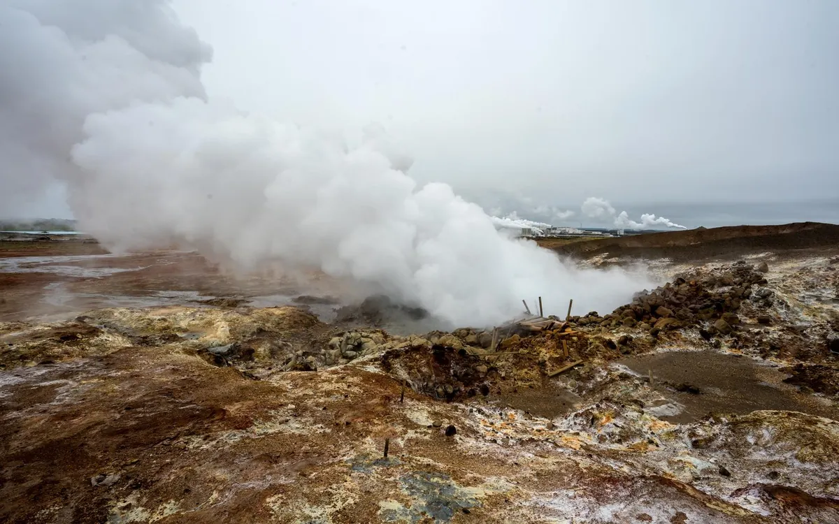 広がる溶岩原の錆色の地面から立ち上る蒸気