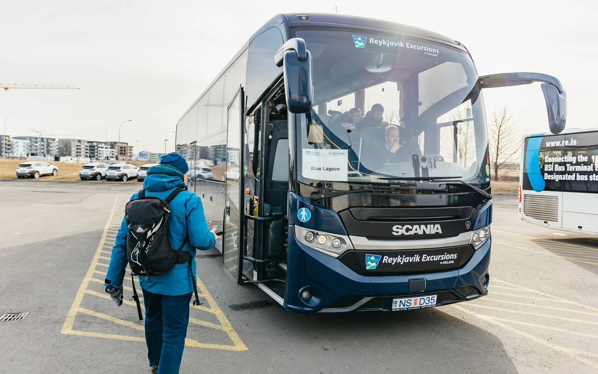 Un autocar de excursión aparcado en una carretera junto a un campo de lava en Islandia