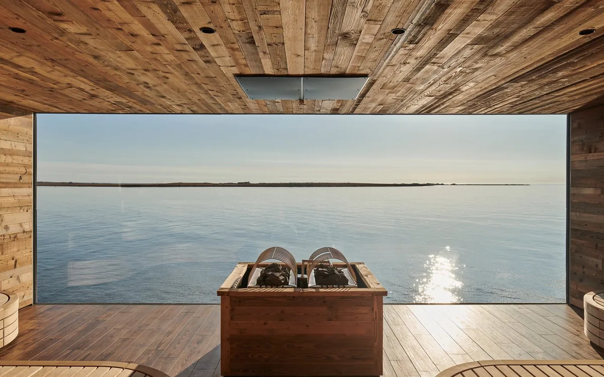 A timber changing building beside a geothermal bathing pool in Iceland